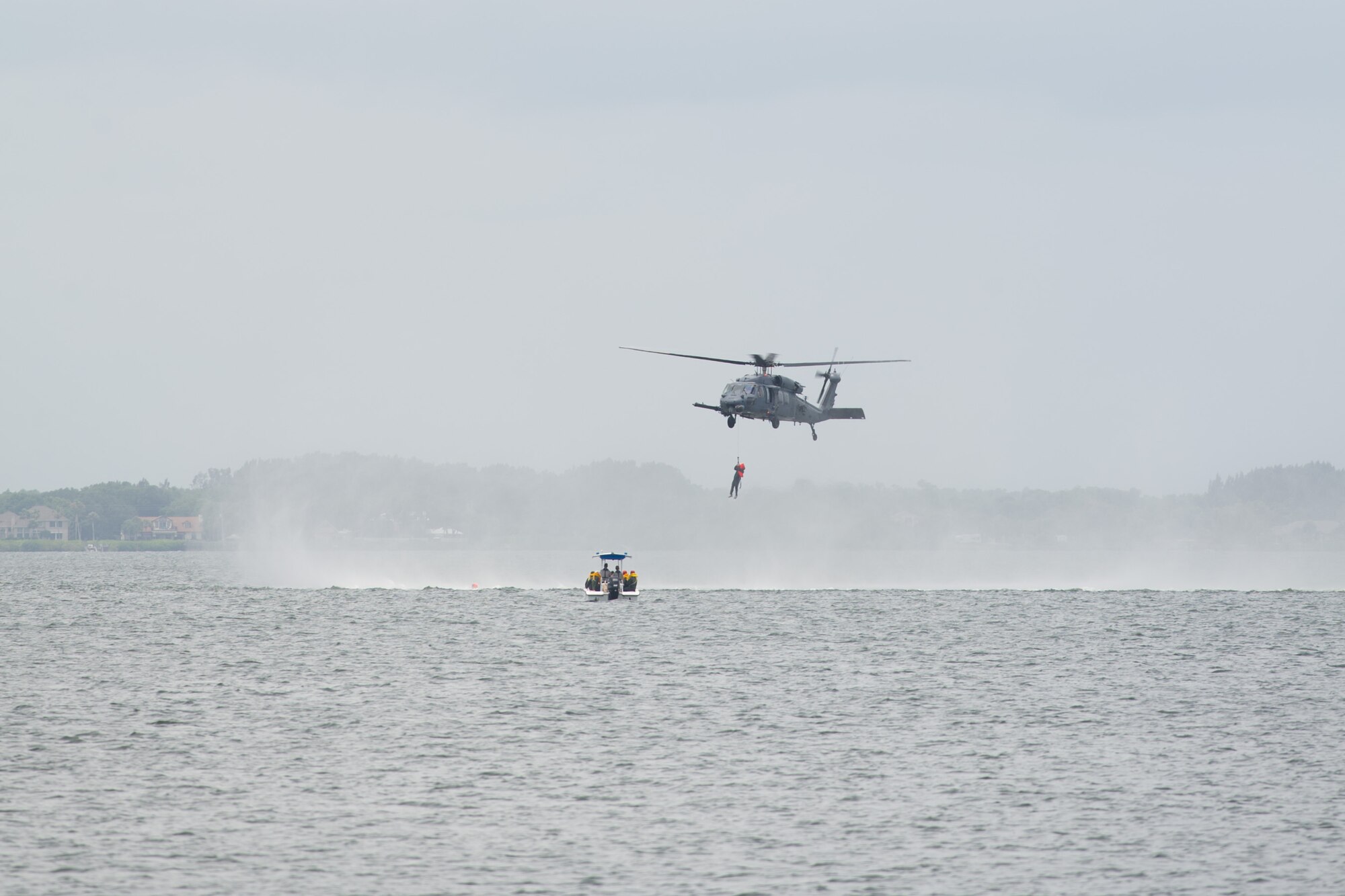 An HH-60 Pave Hawk assigned to the 301st Rescue Squadron, 920th Rescue Wing, rescues and Airman from the 445th Operations Group participating in the aftermath of a simulated plane crash in the Banana River as part of water survival training May 17, 2016 at the Marina, Patrick AFB, Fla. Approximately 60 Airmen from the 89th Airlift Squadron, 445th Aeromedical Evacuation Squadron and 445th Operational Support Squadron (provided the training) descended upon Patrick May 17-19 for their annual water and combat survival training. (U.S. Air Force photos/Benjamin Thacker/Released)