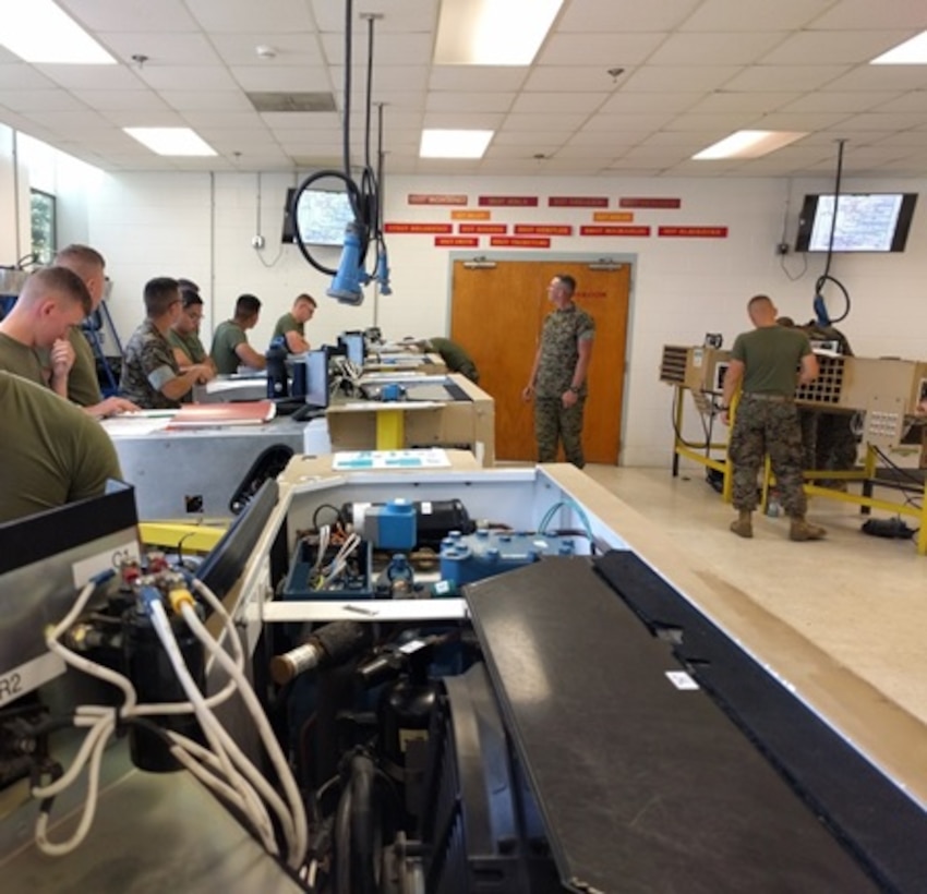 Sergeant Nathan Blackburn, an instructor with Utilities Instruction Company; teaches Marines attached to Basic Refrigeration and Air Conditioning Technician course 3-16 (BRACT 3-16) about the flow of current through the Small Field Refrigeration System (SFRS) by using an electrical schematic during a practical application. 