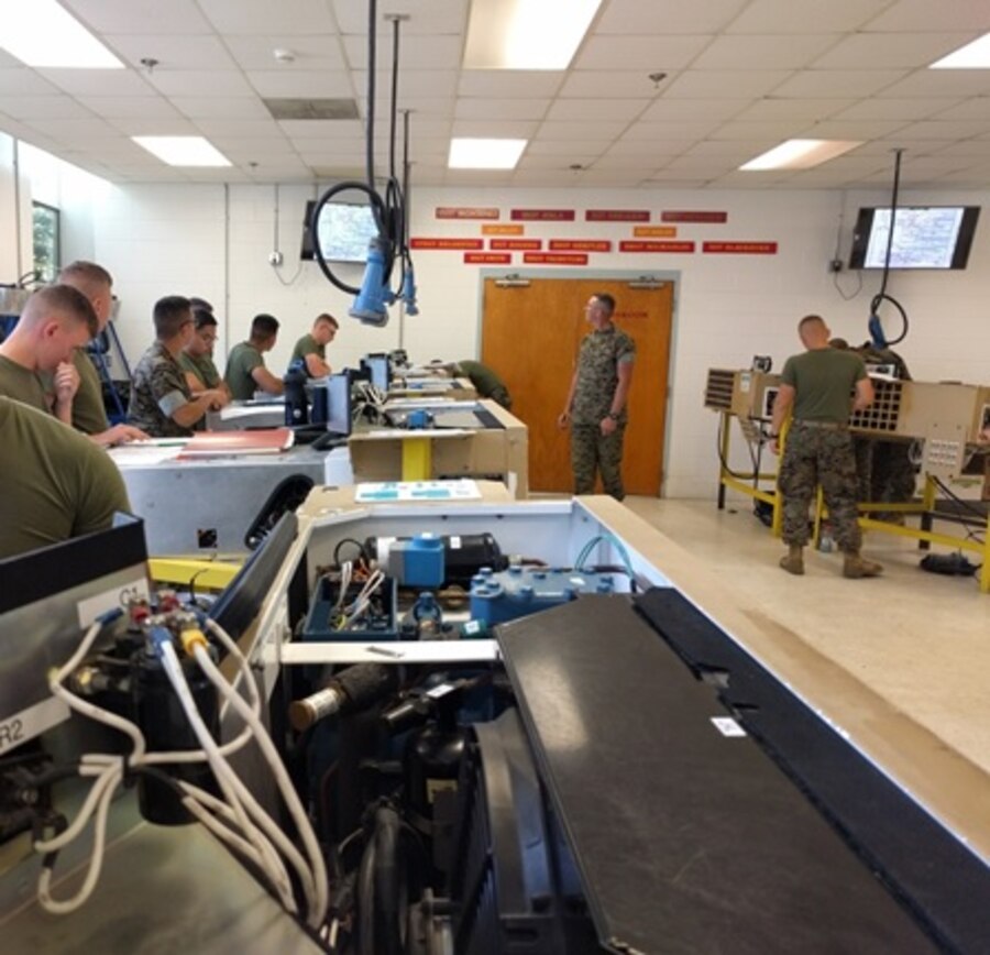Sergeant Nathan Blackburn, an instructor with Utilities Instruction Company; teaches Marines attached to Basic Refrigeration and Air Conditioning Technician course 3-16 (BRACT 3-16) about the flow of current through the Small Field Refrigeration System (SFRS) by using an electrical schematic during a practical application. 