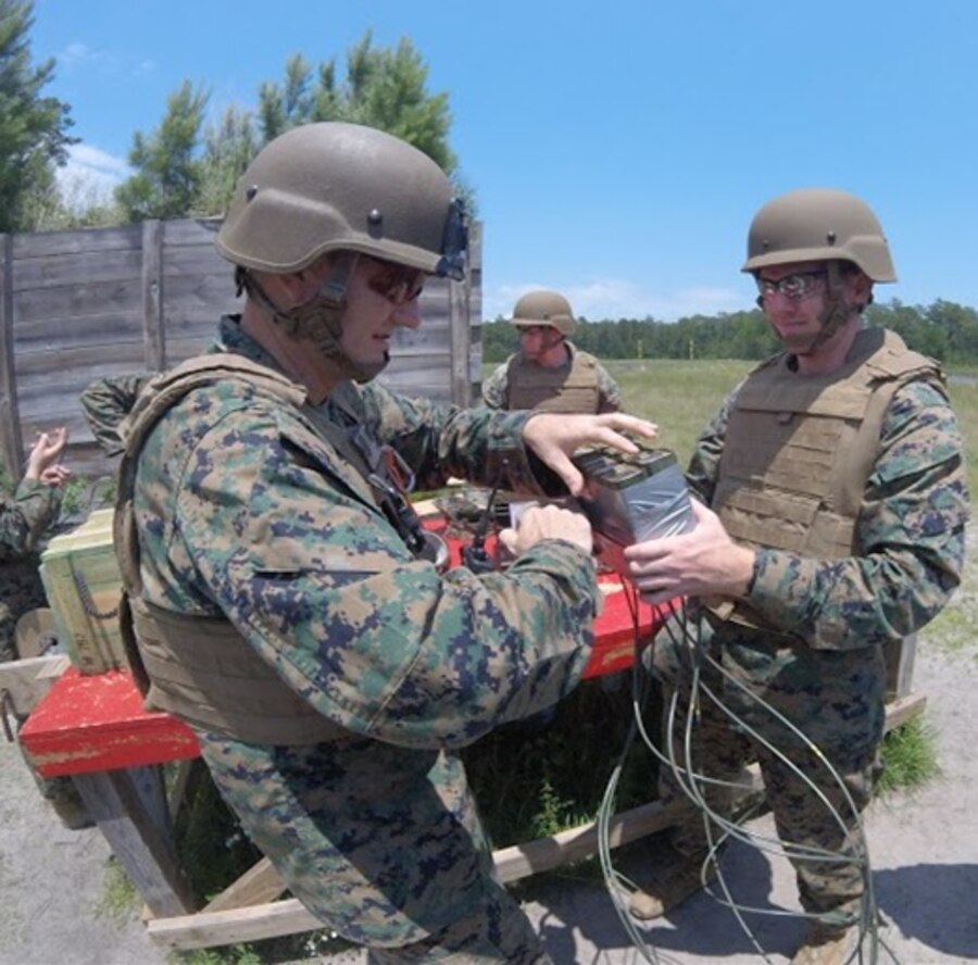 On May 26, 2016 Second Lieutenant Nicholas Downey (right), a Marine attached to Combat Engineer Officer course 5-16 (CEO 5-16), and Gunnery Sergeant John Cheze (left), an instructor with Combat Engineer Instruction Company; tape together sticks of TNT to make an explosive charge at Marine Corps Engineer School aboard Camp Lejeune, N.C. Combat Engineer Officer course students receive instruction on how to construct, emplace, and detonate explosive charges.
