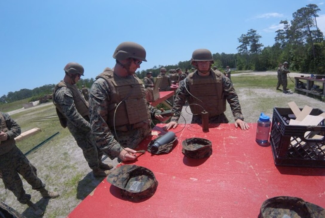 On May 26, 2016 Second Lieutenant Thomas Cofer (front left), a Marine attached to Combat Engineer Officer course 5-16 (CEO 5-16); places a fuse on a one-pound stick of TNT. CEO course students construct and detonate various types of explosive charges throughout military demolitions practical application training. From left to right: Second Lieutenants Justin Wilkison, Thomas Cofer, and Troy Searcy.  