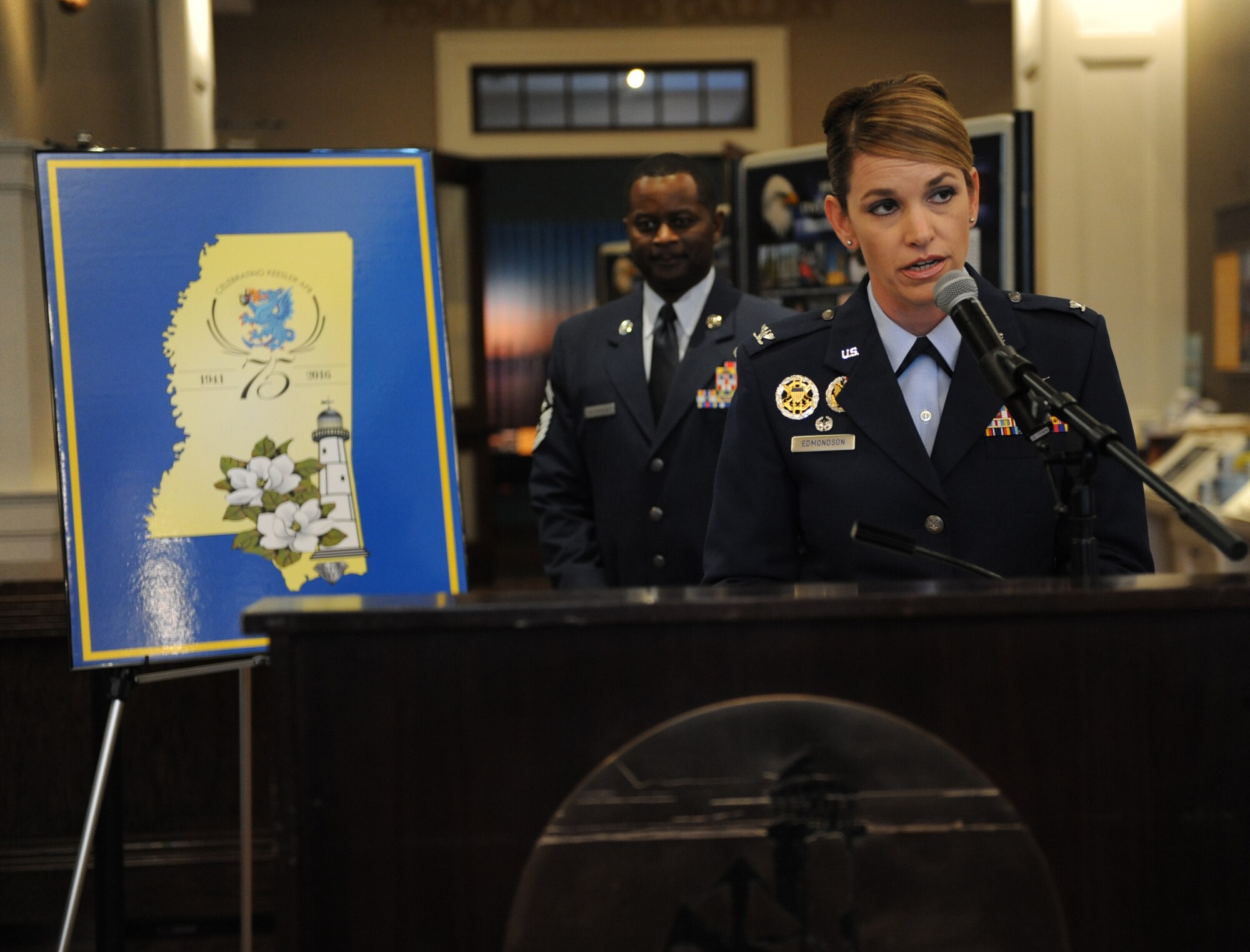 Col. Michele Edmondson, 81st Training Wing commander, unveils the newest 75th anniversary logo during Keesler’s 75th Anniversary Historical Display Unveiling at the Biloxi Visitors Center June 3, 2016, Biloxi, Miss. A display featuring 14 historical panels created by Keesler personnel was also unveiled. Additionally, Biloxi Mayor Andrew ‘FoFo’ Gilich read the “Biloxi/Keesler Partnership Day” proclamation. (U.S. Air Force photo by Kemberly Groue)