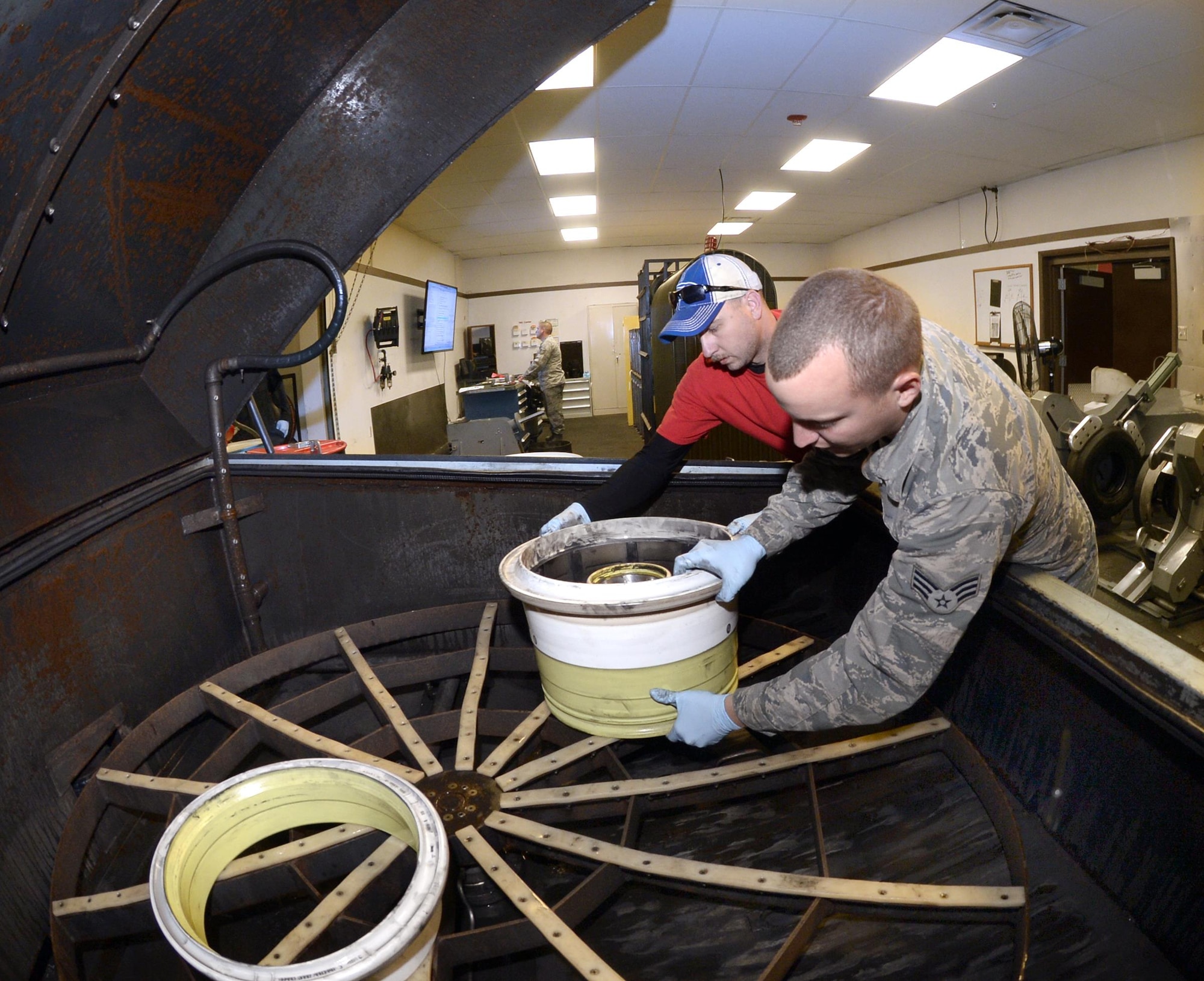 Tech. Sgt. James Speicher, an air reserve technician with the 419th Maintenance Squadron, and Senior Airman Joseph Sprowls, of the 388th Maintenance Squadron, load F-35 Lightning II wheels into a parts washer May 20, 2016, at Hill Air Force Base, Utah. (U.S. Air Force photo/Todd Cromar)