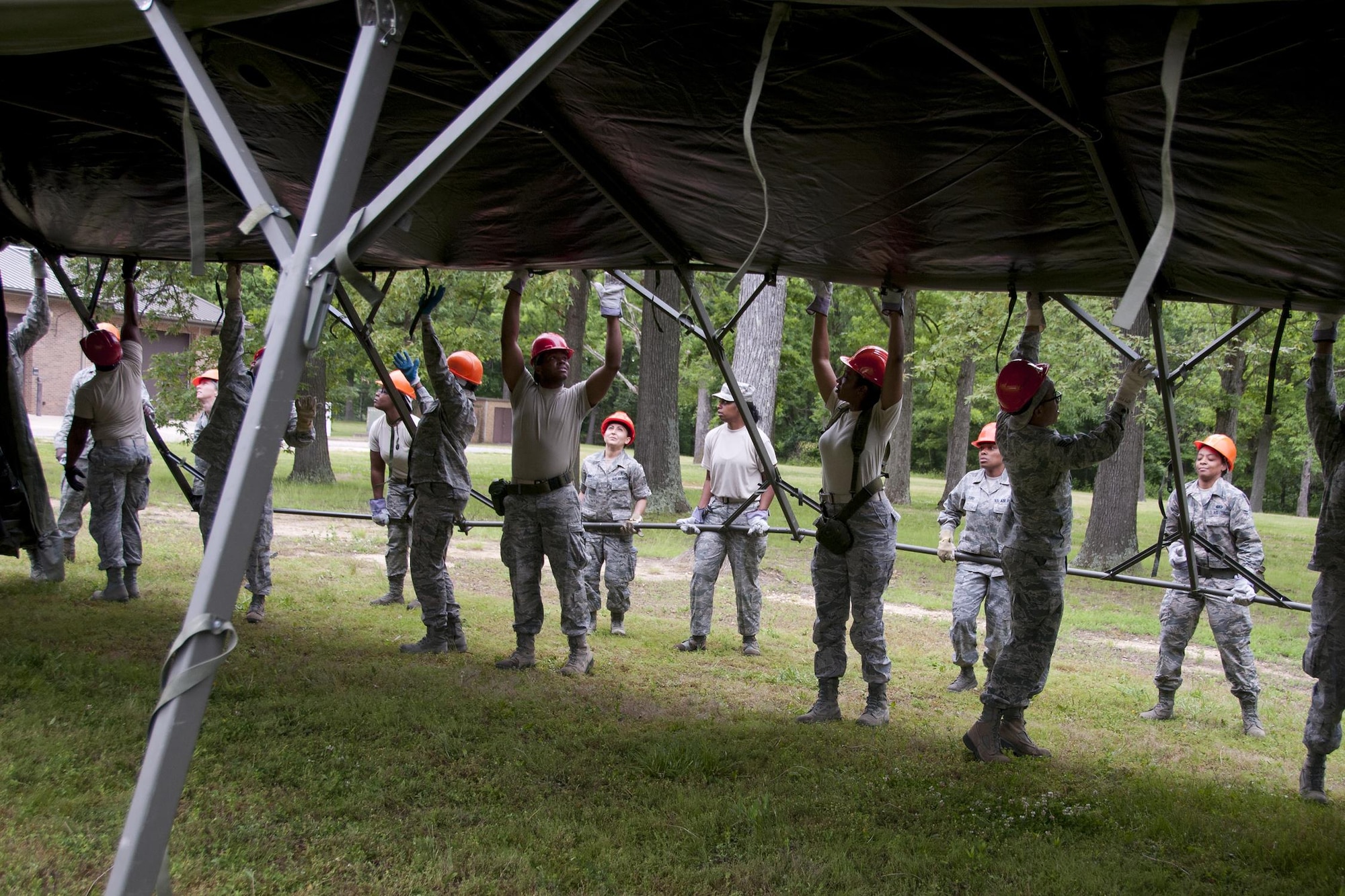 Members of the 459th Force Support Squadron services section build lodging tents as part of a Sustainment Bed Down of Forces exercise on Joint Base Andrews, Md., June 2, 2016. The exercise simulates Airmen deploying as advance echelon and follow on teams into a bare base, where they stand up food, lodging, fitness, recreation and mortuary services prior to the arrival of tenant forces.  (U.S. Air Force photo/Staff Sgt. Kat Justen) 