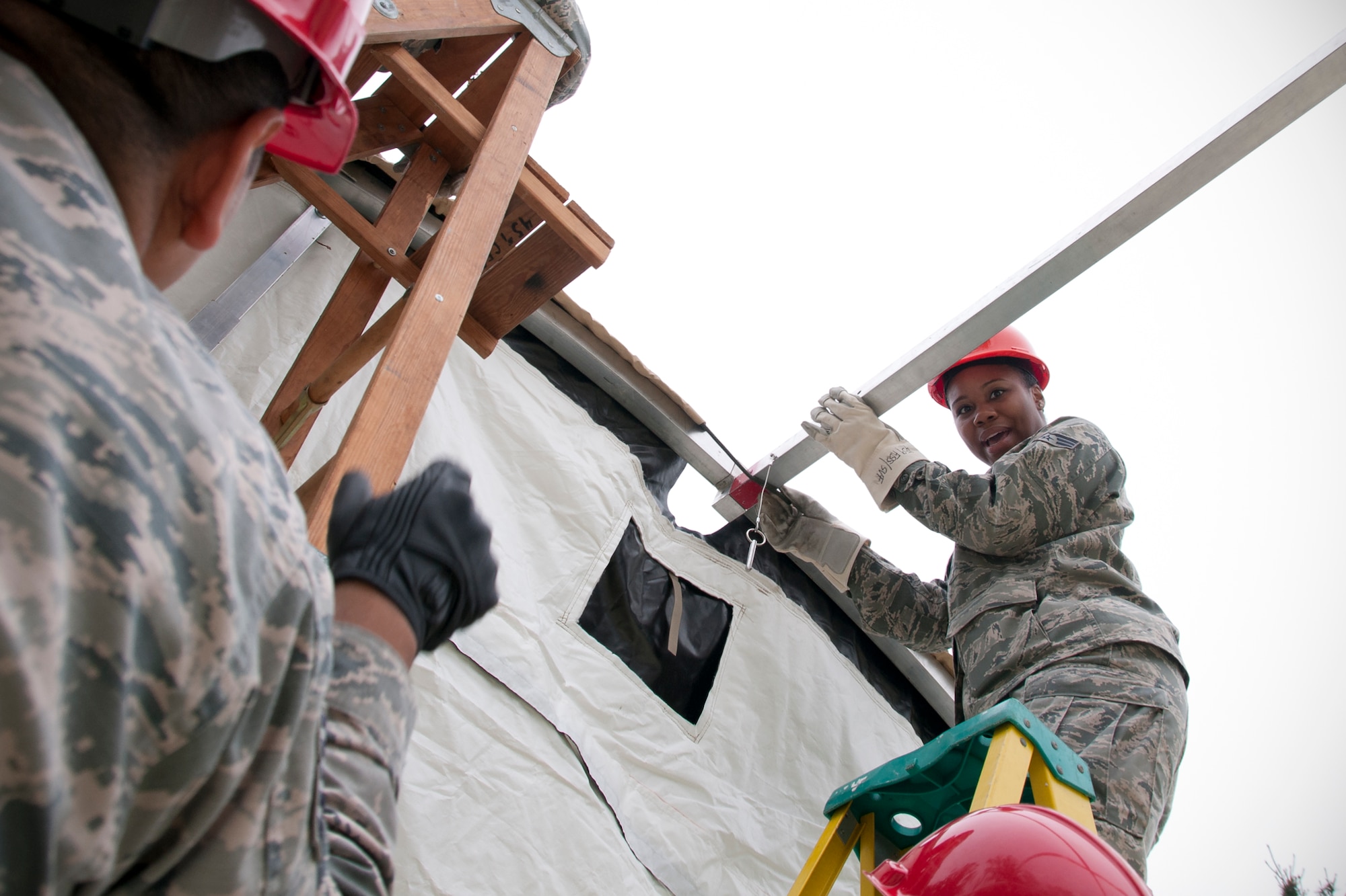 Senior Airman Kenya Lewis, 459th Force Support Squadron services specialist, discusses proper tent construction with a fellow 459th FSS members during a Sustainment Bed Down of Forces exercise on Joint Base Andrews, Md., June 2, 2016. The exercise simulates Airmen deploying as advance echelon and follow-on teams into a bare base, where they stand up food, lodging, fitness, recreation and mortuary services prior to the arrival of tenant forces.  (U.S. Air Force photo/Staff Sgt. Kat Justen)