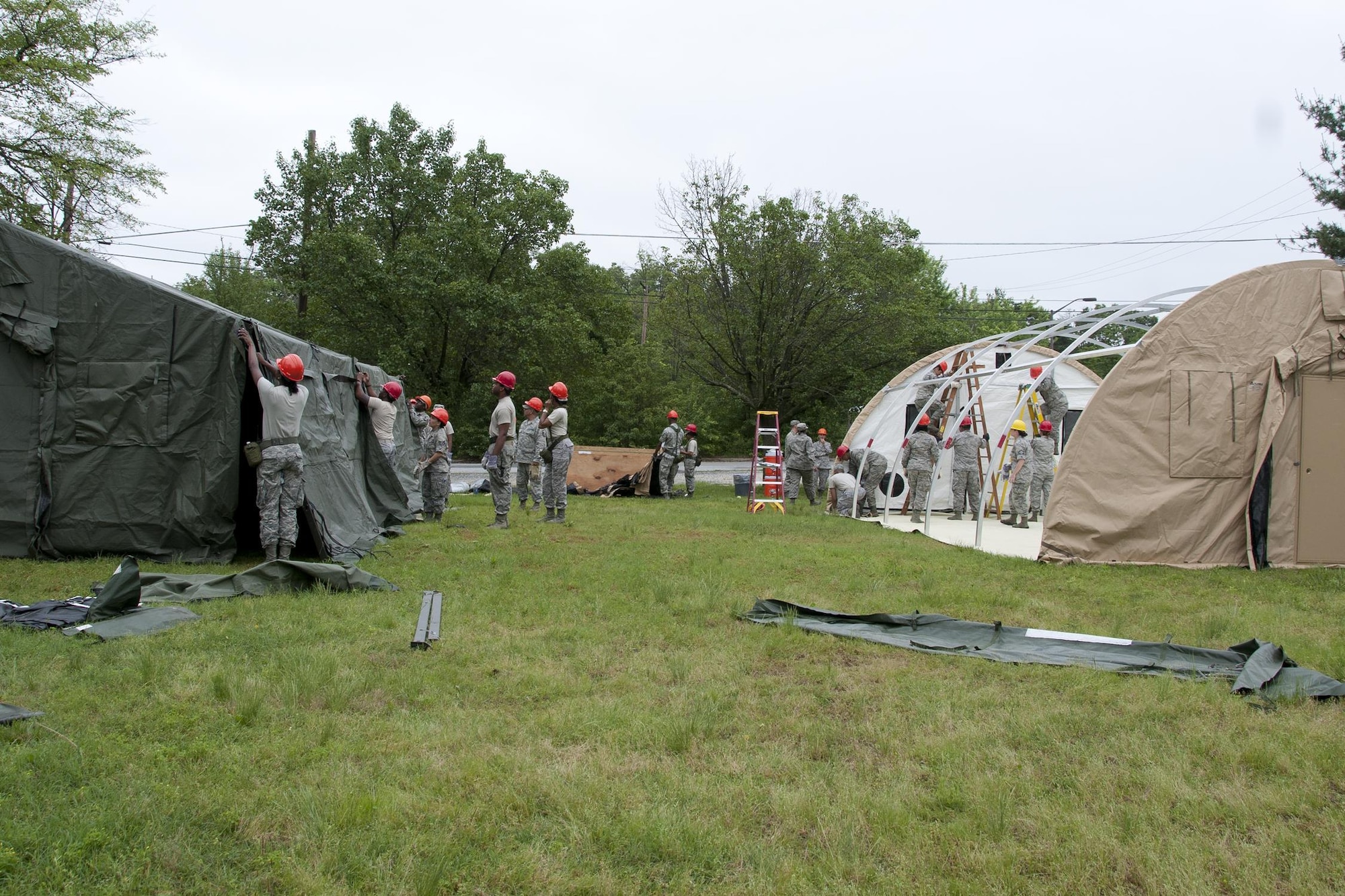 Members of the 459th Force Support Squadron services section build lodging tents as part of a Sustainment Bed Down of Forces exercise on Joint Base Andrews, Md., June 2, 2016. The exercise simulates Airmen deploying as advance echelon and follow-on teams into a bare base, where they stand up food, lodging, fitness, recreation and mortuary services prior to the arrival of tenant forces.  (U.S. Air Force photo/Staff Sgt. Kat Justen) 