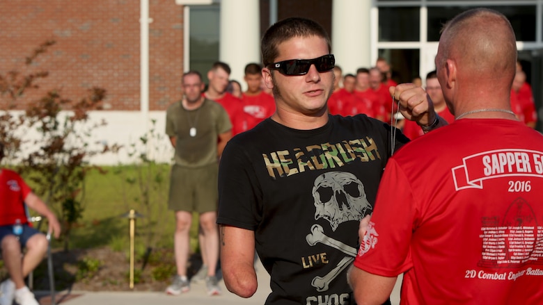 JB Kearns, a former member of 2nd Combat Engineer Battalion, presents Lt. Col. Gary McCullar, the battalion commander of 2nd CEB, with the dog tag of Staff Sgt. Jason Rogers during the “Sapper 50” memorial run at Marine Corps Base Camp Lejeune, North Carolina, June 4, 2016. The run was to honor the 29 fallen CEB Marines who gave their lives during Operations Enduring Freedom and Iraqi Freedom. Kearns came to support the Marines during the run and honor Rogers who saved his life during OEF.