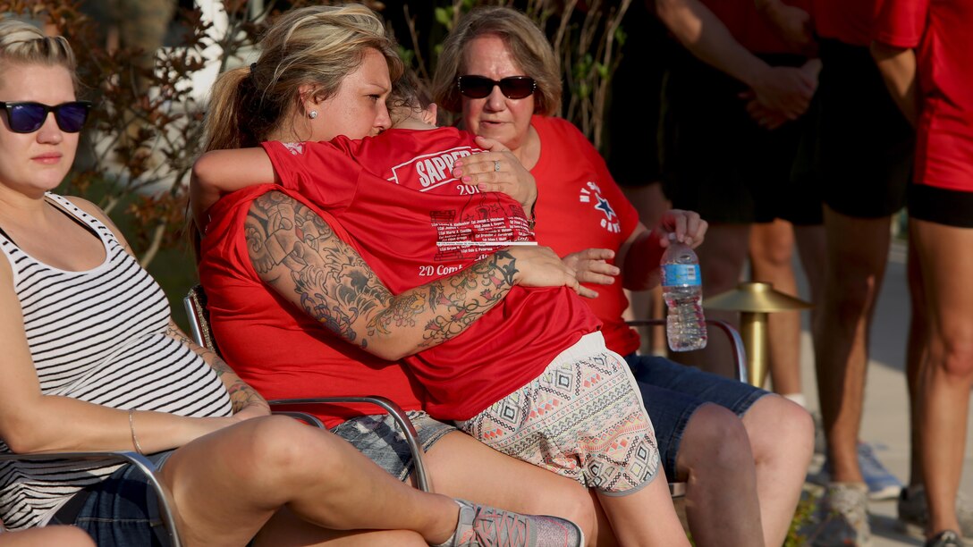 Erica Wallace, the widow of Sgt. David Wallace III, who was killed in action during Operation Enduring Freedom, comforts her daughter Brookelyn Wallace after she presented Lt. Col. Gary McCullar, the battalion commander of 2nd Combat Engineer Battalion, with the dog tag of Wallace during the Sapper 50 memorial run at Marine Corps Base Camp Lejeune, North Carolina, June 4, 2016. The run was to honor the 29 fallen CEB Marines who gave their lives during Operations Enduring Freedom and Iraqi Freedom.  Brookelyn carried her father’s dog tag the final mile of the run and participated in the closing ceremony by presenting her father’s dog tag.