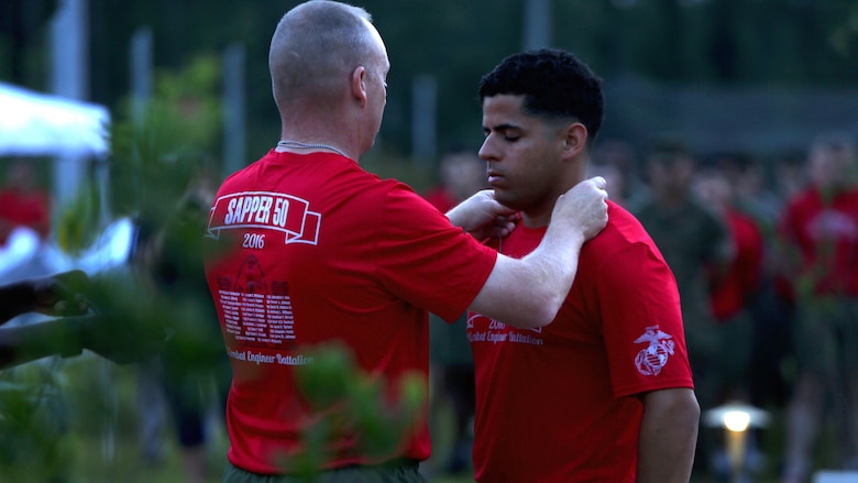 Lt. Col. Gary McCullar, the battalion commander of 2nd Combat Engineer Battalion, presents 1st Lt. Armando Torres, a combat engineer officer, 2nd CEB, with the dog tag of a fallen Marine during the Sapper 50 memorial run at Marine Corps Base Camp Lejeune, North Carolina, June 4, 2016. The run was to honor the 29 fallen CEB Marines who gave their lives during Operations Enduring Freedom and Iraqi Freedom.  The 29 dog tags from the fallen Marines were passed from Marine to Marine every five miles until the 50-mile run was completed.