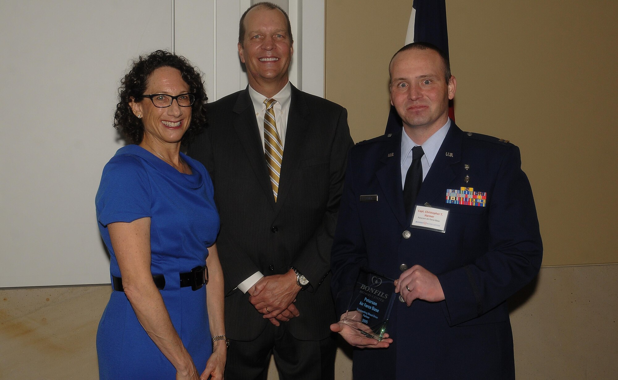 COLORADO SPRINGS, Colo. -- Capt. Christopher Harmer, 21st Medical Group, receives the Bonfils Blood Center Outstanding Blood Drive Partner award on behalf of Peterson Air Force Base for exemplary efforts in blood drive participation in 2015. Bonfils CEO Bryan Kreuger presented the award and Susan Witkin, KOA News Radio, was emcee. (Courtesy Photo)