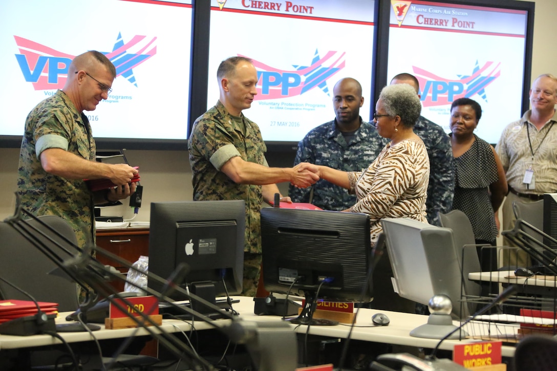 Col. Chris C. Pappas III awards departments during a Voluntary Protection Program Gold status achievement ceremony at Marine Corps Air Station Cherry Point, N.C., May 27, 2016. Six departments were among the first to achieve Gold status within MCAS Cherry Point VPP. Gold status is achieved when all safety protocols implemented by the VPP are completed and maintained. Some of those requirements involve monthly supervisor inspections, achieving 90-percent medical surveillance or higher, completing VPP passports and completing Occupational Safety and Health Administration training. Pappas is the air station commanding officer. (U.S. Marine Corps photo by Cpl. N.W. Huertas/ Released)