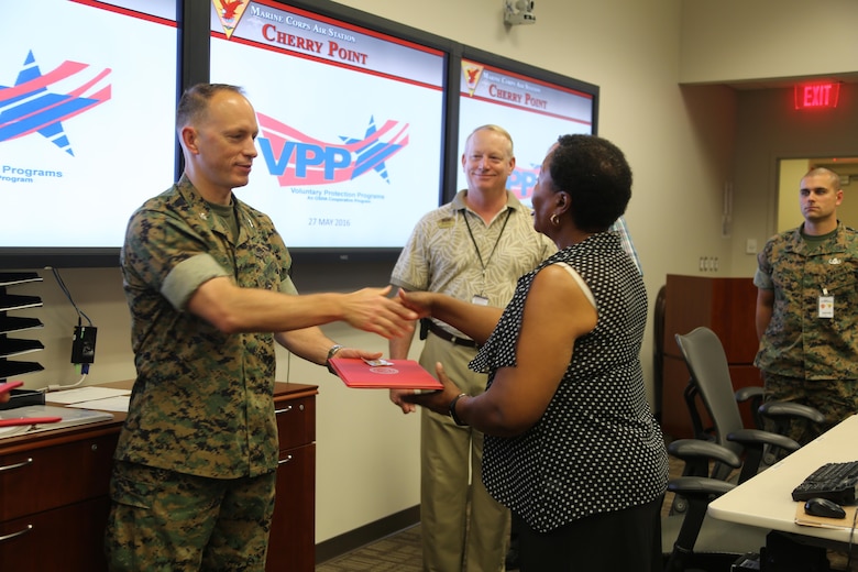 Col. Chris C. Pappas III awards departments during a Voluntary Protection Program Gold status achievement ceremony at Marine Corps Air Station Cherry Point, N.C., May 27, 2016. Six departments were among the first to achieve Gold status within MCAS Cherry Point VPP. Gold status is achieved when all safety protocols implemented by the VPP are completed and maintained. Some of those requirements involve monthly supervisor inspections, achieving 90-percent medical surveillance or higher, completing VPP passports and completing Occupational Safety and Health Administration training. Pappas is the air station commanding officer.  (U.S. Marine Corps photo by Cpl. N.W. Huertas/ Released) 