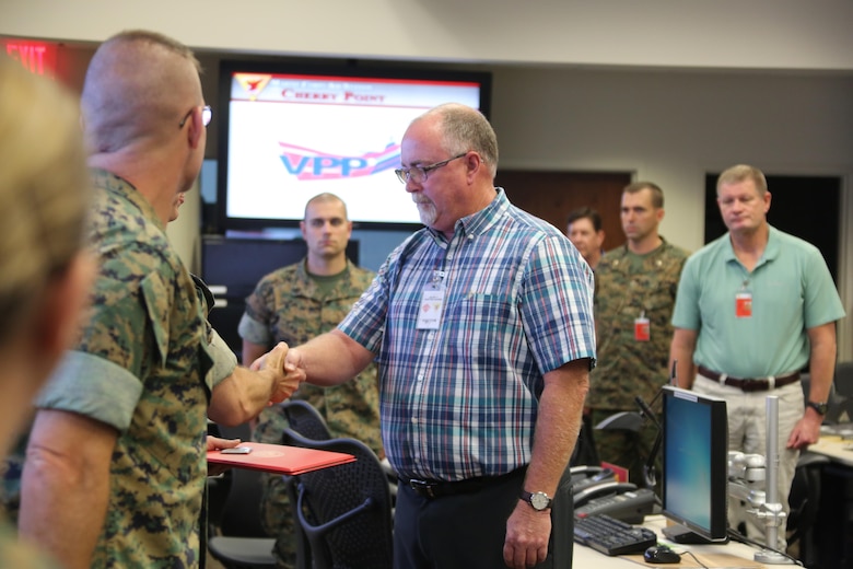 Department representatives receive Gold status achievement awards during a Voluntary Protection Program Gold status achievement ceremony at Marine Corps Air Station Cherry Point, N.C., May 27, 2016. Six departments were among the first to achieve Gold status within MCAS Cherry Point VPP. Gold status is achieved when all safety protocols implemented by the VPP are completed and maintained. Some of those requirements involve monthly supervisor inspections, achieving 90-percent medical surveillance or higher, completing VPP passports and completing Occupational Safety and Health Administration training. (U.S. Marine Corps photo by Cpl. N.W. Huertas/ Released)