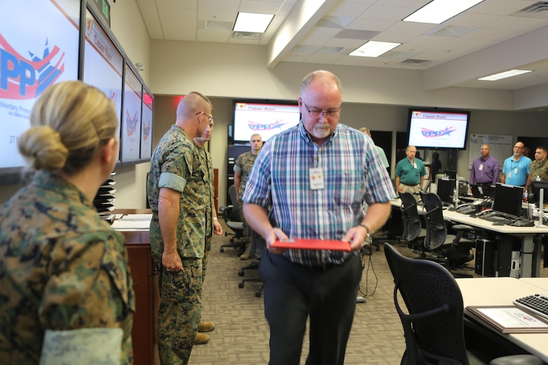 Department representatives receive Gold status achievement awards during a Voluntary Protection Program Gold status achievement ceremony at Marine Corps Air Station Cherry Point, N.C., May 27, 2016. Six departments were among the first to achieve Gold status within MCAS Cherry Point VPP. Gold status is achieved when all safety protocols implemented by the VPP are completed and maintained. Some of those requirements involve monthly supervisor inspections, achieving 90-percent medical surveillance or higher, completing VPP passports and completing Occupational Safety and Health Administration training. (U.S. Marine Corps photo by Cpl. N.W. Huertas/ Released) 