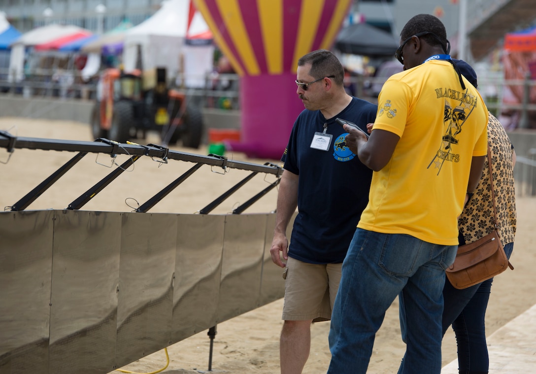 VIRGINIA BEACH, Va. - A U.S. Navy sailor volunteers to help people find names of their friends and loved ones on The Wall That Heals. The Wall That Heals, a half replica of the Vietnam Memorial in Washington D.C., stops in Virginia Beach, June 3-5. Marines and sailors volunteered to help people locate names of their loved ones on the wall. The traveling exhibit provides thousands of veterans who have been unable to cope with the prospect of facing The Wall to find the strength and courage tk do so within their own communities, thus allowing the healing process to begin. (U.S. Marine Corps photo by Cpl. Logan Snyder)