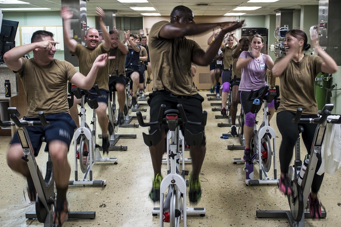 Navy Seaman Derek Drummond leads fellow Seabees in a motivated clap during a spin class aboard hospital ship USNS Mercy in the Pacific Ocean, June 6, 2016. The Mercy is supporting Pacific Partnership 2016. Drummond is a construction electrician constructionman. Navy photo by Petty Officer 3rd Class Trevor Kohlrus