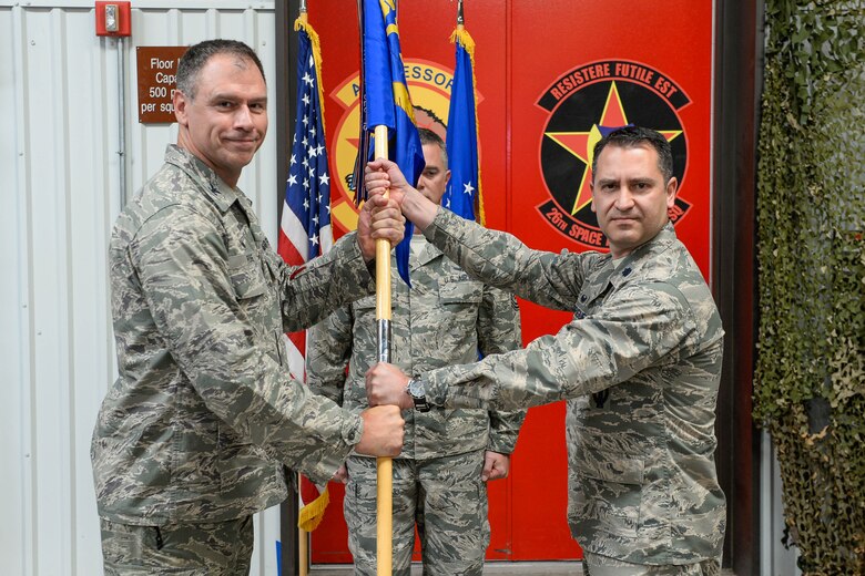 Col. Gary Rose, 57th Adversary Tactics Group commander, presents the guidon to Lt. Col. Anibal Rodriguez during the 527th Space Aggressors Squadron’s change of command at Schriever Air Force Base, Colorado, Thursday, June 2, 2016. Rodriguez assumes the 527 SAS command from Lt. Col. Kyle Pumroy. (U.S. Air Force photo/Christopher DeWitt)