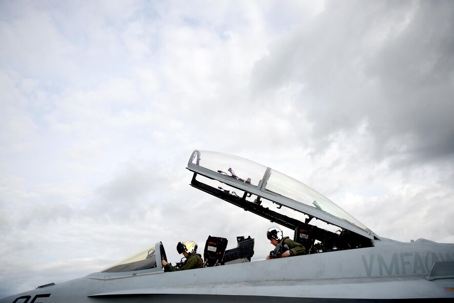 U.S. Marine Corps F-18 Hornet pilots assigned to Fixed Marine All-Weather Fighter Attack Squadron 242, Marine Corps Air Station Iwakuni, Japan, secure themselves inside their cockpit June 7, 2016, during RED FLAG-Alaska (RF-A)16-2, at Eielson Air Force Base, Alaska. Pilots involved with RF-A are exposed to realistic combat training supported by the 18th Aggressor Squadron, which shares knowledge of flying and provides the best air combat training possible. (U.S. Air Force photo by Tech. Sgt. Steven R. Doty)