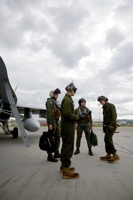 U.S. Marine Corps Cpl. Austin Perry, front center, an F-18 Hornet powerline mechanic and plane captain assigned to Fixed Marine All-Weather Fighter Attack Squadron (VMFA (AW)) 242, Marine Corps Air Station Iwakuni, Japan, communicates with operations staff over the radio June 7, 2016, during RED FLAG-Alaska (RF-A) 16-2, at Eielson Air Force Base, Alaska. VFMA (AW) is one of more than 30 units participating in RF-A 16-2 that benefits from the unique opportunity to integrate with various joint, coalition and multilateral forces to train at a simulated forward operating base. (U.S. Air Force photo by Tech. Sgt. Steven R. Doty)