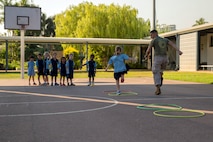 Lance Cpl. Adrian Lozano runs with a student during physical education at Larrakeyah Primary School, Northern Territory, Australia, on June 2, 2016. Marines with the Forward Coordination Element, Marine Rotational Force – Darwin, volunteered to help with classes at the school. Lozano, from Los Angeles, California, is an administration specialist with FCE, MRF-D.