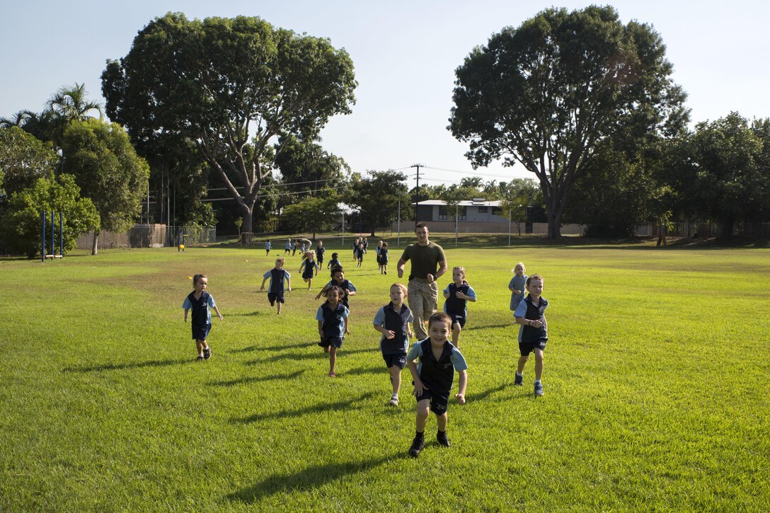 Lance Cpl. Matthew T. Bowden runs with students during physical education at Larrakeyah Primary School, Northern Territory, Australia, on June 2, 2016. Marines with the Forward Coordination Element, Marine Rotational Force – Darwin, volunteered to help with classes at the school. Bowden, from Manville, New Jersey, is a cyber network operator with FCE, MRF-D.