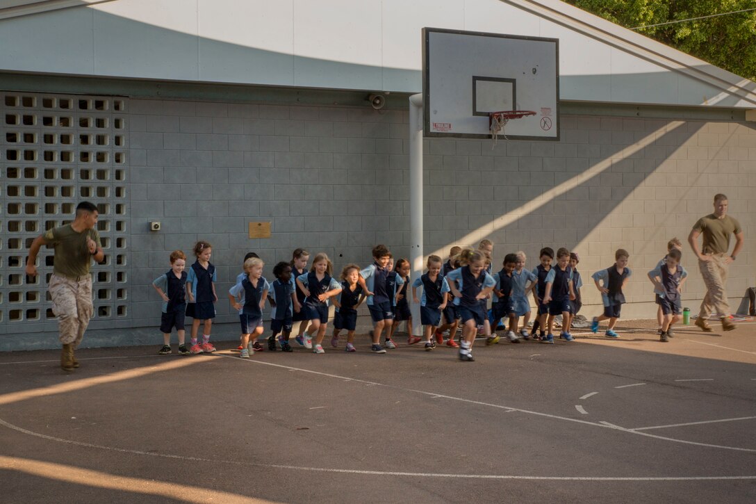 Lance Cpl. Adrian Lozano, an administrative specialist, and Lance Cpl. Matthew T. Bowden, a cyber network operator, run with students during physical education at Larrakeyah Primary School, Northern Territory, Australia, on June 2, 2016. Marines with the Forward Coordination Element, Marine Rotational Force – Darwin, volunteered to help with classes at the school. Lozano, from Los Angeles, California, and Bowden, from Manville, New Jersey, are with FCE, MRF-D.