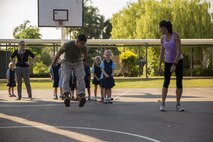 Lance Cpl. Adrian Lozano shows students how to long jump during physical education at Larrakeyah Primary School, Northern Territory, Australia, on June 2, 2016. Marines with the Forward Coordination Element, Marine Rotational Force – Darwin, volunteered to help with classes at the school. Lozano, from Los Angeles, California, is an administration specialist with FCE, MRF-D.