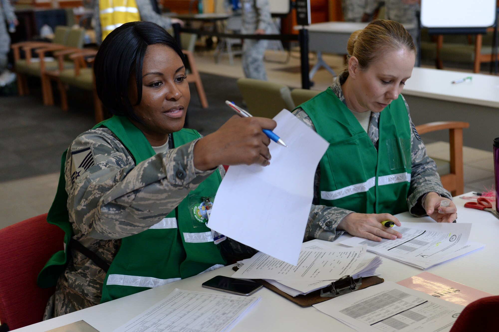 U.S. Air Force Master Sgt. Ukeia Carter, 36th Medical Support Squadron superintendent, left, and Tech. Sgt. Gretchen Hopper, 36th MDSS TRICARE operations and patient administration flight NCO in charge, check in patients during a typhoon recovery exercise June 6, 2016, at Andersen Air Force Base, Guam. The 36th Medical Group performed typhoon recovery response, to include flu o-utbreak mitigation, assessment of injured personnel and providing aid to large numbers of patients at one time. (U.S. Air Force photo by Airman 1st Class Alexa Ann Henderson/Released)