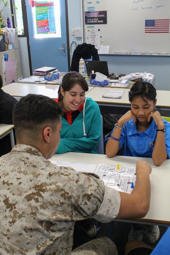 Lance Cpl. Simon B. Delacruz Jr. plays a board game with students at Sanderson Middle School, Northern Territory, Australia, on June 3, 2016. Marines with the Forward Coordination Element, Marine Rotational Force – Darwin, helped with an English oral language class by talking, playing and listening to middle school students. Delacruz, from Rochester, New York, is a cyber network operator with FCE, MRF-D.