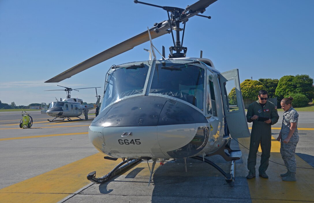 Members of the 459th Airlift Squadron perform a pre-flight inspection prior to a formation flight at Yokota Air Base, Japan, June 3, 2016. A formation flight is any flight with two or more aircraft flying together. (U.S. Air Force photo by Senior Airman David Owsianka/Released)