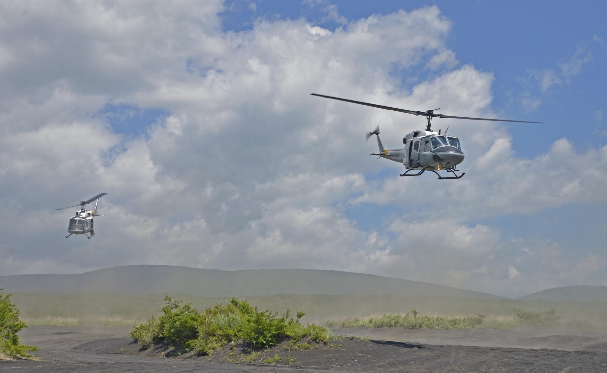 Two UH-1N Iroquois with the 459th Airlift Squadron fly over a drop zone near Mt. Fuji, Japan, June 3, 2016. In peacetime, aircraft will fly in formation to complete missions and training in which aircraft cannot transport all the people or cargo on its own. (U.S. Air Force photo by Senior Airman David Owsianka/Released)