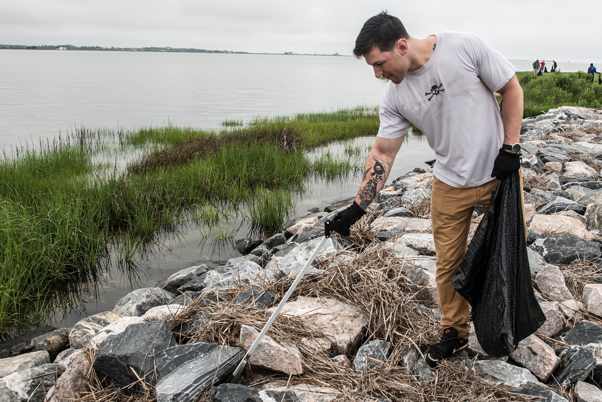 U.S. Army Sgt. Jesse Thompson, Advanced Individual Training instructor assigned to the 128th Aviation Brigade, picks up trash during the 28th annual Clean the Bay Day at Langley Air Force Base, Va., June 4, 2016. The volunteer’s efforts affect the Chesapeake Bay, which is one of America’s largest seafood suppliers, according to the National Park Service. (U.S. Air Force photo by Airman 1st Class Derek Seifert)