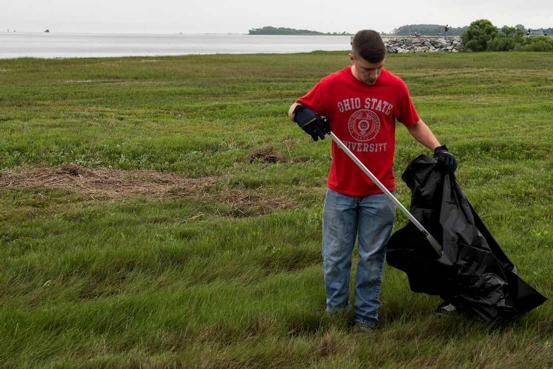 U.S. Air Force 1st Lt. Eric Danko, Readiness and Emergency Management flight commander assigned to the 633rd Logistics Readiness Squadron, picks up trash during the 28th annual Clean the Bay Day at Langley Air Force Base, Va., June 4, 2016. Since the day’s inception in 1989, volunteers have removed nearly 6.2 million pounds of trash. (U.S. Air Force photo by Airman 1st Class Derek Seifert)