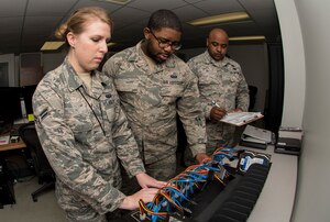 U.S. Air Force Staff Sgt. Tajwalid, quality assurance officer for the 363rd Intelligence, Surveillance and Reconnaissance Wing, evaluates Airmen 1st Class Jenny and William, cyber systems operators assigned to the 363rd Intelligence Support Squadron, as they perform tasks for cloning hard drives at Langley Air Force Base, Va., May 24, 2016. Cyber system operators must quickly respond to service outages and interruptions to network operations. (U.S. Air Force photo by Airman 1st Class Derek Seifert)
