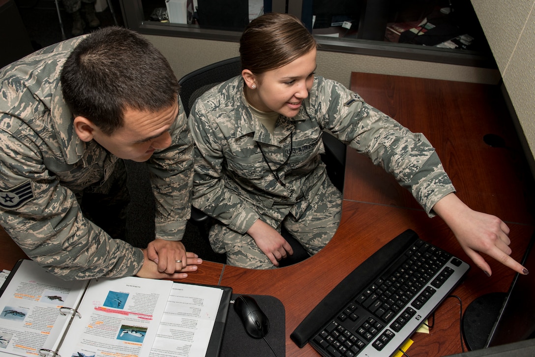 U.S. Air Force Airman Lauren and Staff Sgt. Michael, target system analysts for the 15th Intelligence Squadron, discuss career development courses and operational targeting training at Langley Air Force Base, Va., May 24, 2016. The 15th IS is part of the 365th Intelligence, Surveillance and Reconnaissance Group, 363rd ISR Wing, which serves as content-dominant analysis, precision targeting production, and special operations ISR for the tactical warfighter, enabling combat power in air, space, and cyberspace. (U.S. Air Force photo by Airman 1st Class Derek Seifert)