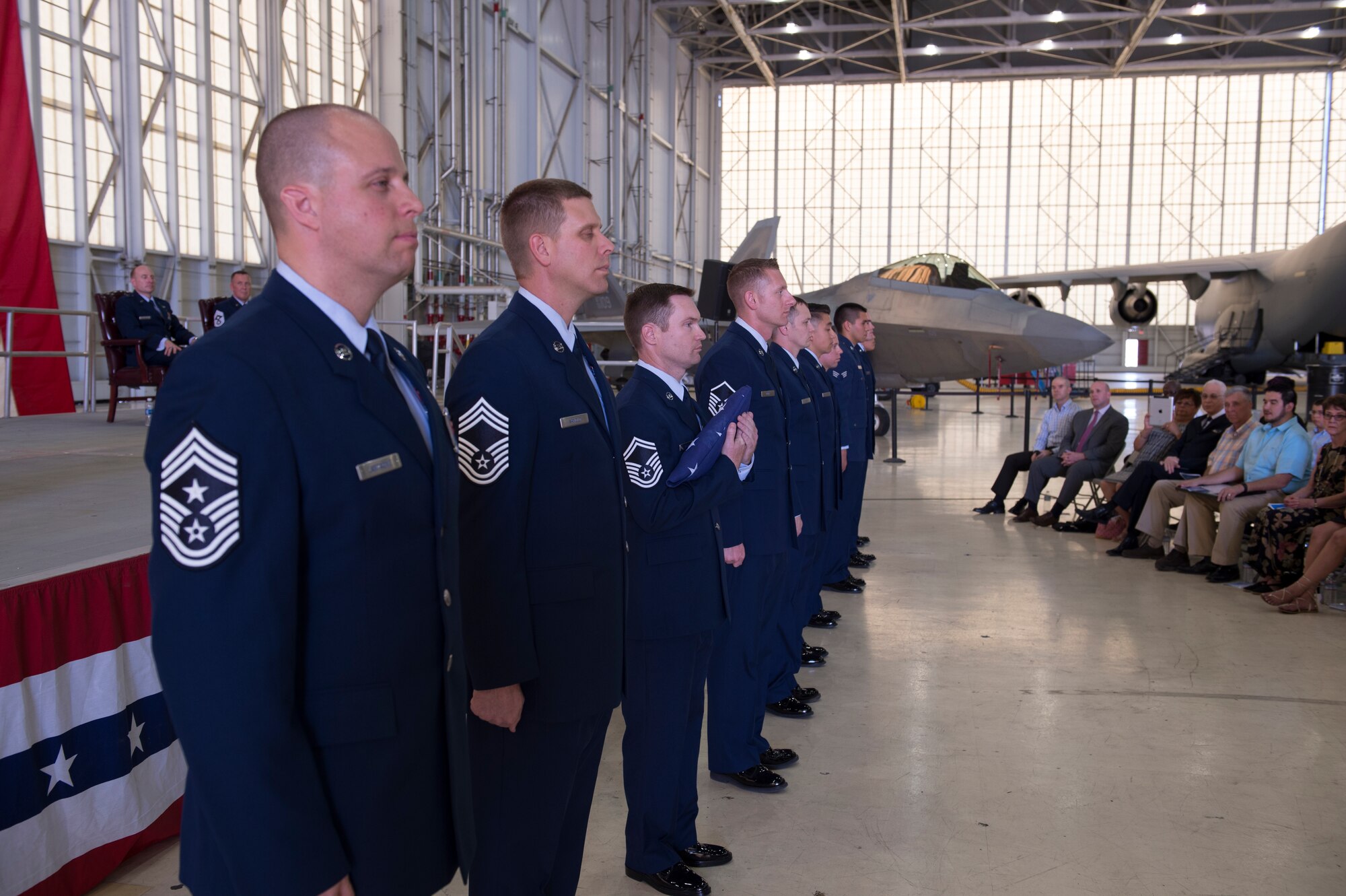 Members of Team Edwards, representing all enlisted ranks, perform the flag passing ceremony commemorating the different stages of Chief Master Sgt. David Smith’s career during his retirement ceremony June 3. Smith retired as command chief master sergeant for the 412th Test Wing here. (U.S. Air Force photo by Joseph Pol Gocong.)