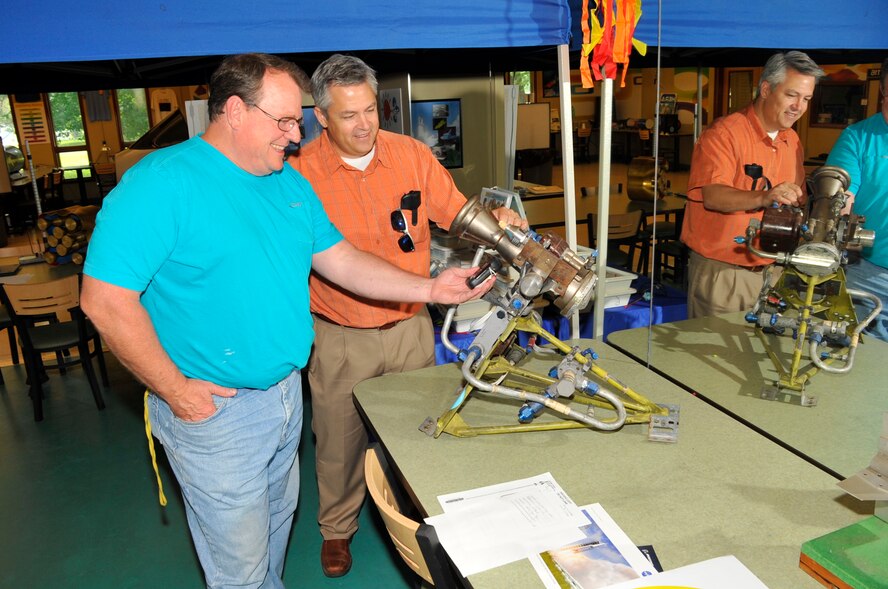 Chris Rumley, back right, and Mike Frederick, ATA industrial hygienist, inspect a Vernier rocket engine on display at the Science, Technology, Engineering and Mathematics Center at Arnold Air Force Base. (U.S. Air Force photo/Rick Goodfriend)