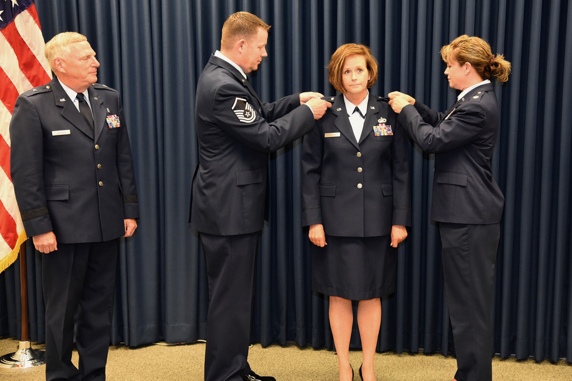 Col. Laurie Tidemann, HQ SDANG strategic plans officer, is pinned with her new rank by her siblings, Master Sgt. Eric Tidemann, 114th Fighter Wing recruiting office supervisor, and Major Lisa Tidemann, 114th Logistics Readiness Squadron officer, in a ceremony held at Joe Foss Field, S.D. June 4, 2016.  The Tidemann family has a long line of service in the South Dakota Air National Guard starting with the father, retired Col. Merlyn Tidemann, former 114th Maintenance Group commander. (U.S. Air National Guard photo by Staff Sgt. Luke Olson/Released)