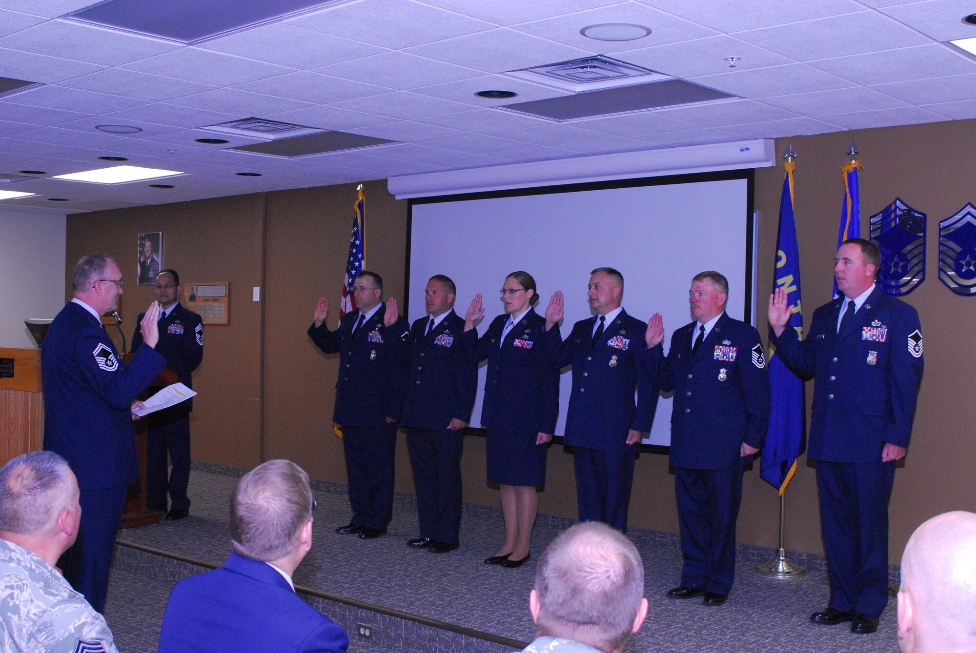 Senior Master Sgt. Bill Shirley, superintendent of inspections, inducts six of the newest master sergeants in the 120th Airlift Wing Larsen room, June 4, 2016. Attaining the rank of master sergeant allows the members to be a part of an elite group called the Top 3. (U.S. Air National Guard photo by Staff Sgt. Lindsey Soulsby/Released)