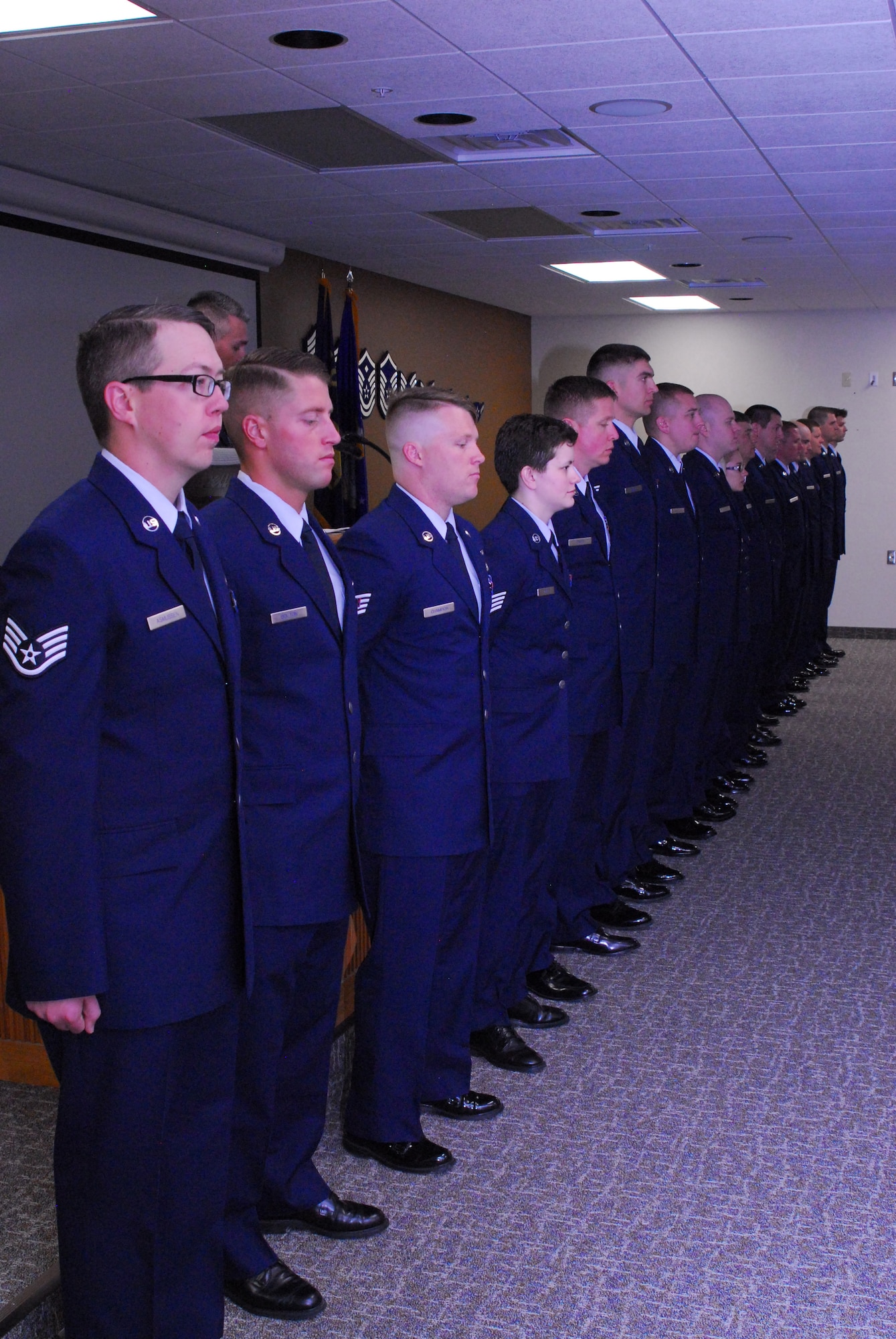 Seventeen Vigilantes of the Montana Air National Guard stand at attention to be recognized for their recent promotion to staff sergeant in the Larson room June 4, 2016. These members have left the rank of senior airmen and will take on supervisory duties with their new rank.  (U.S. Air National Guard photo by Staff Sgt. Lindsey Soulsby/Released)