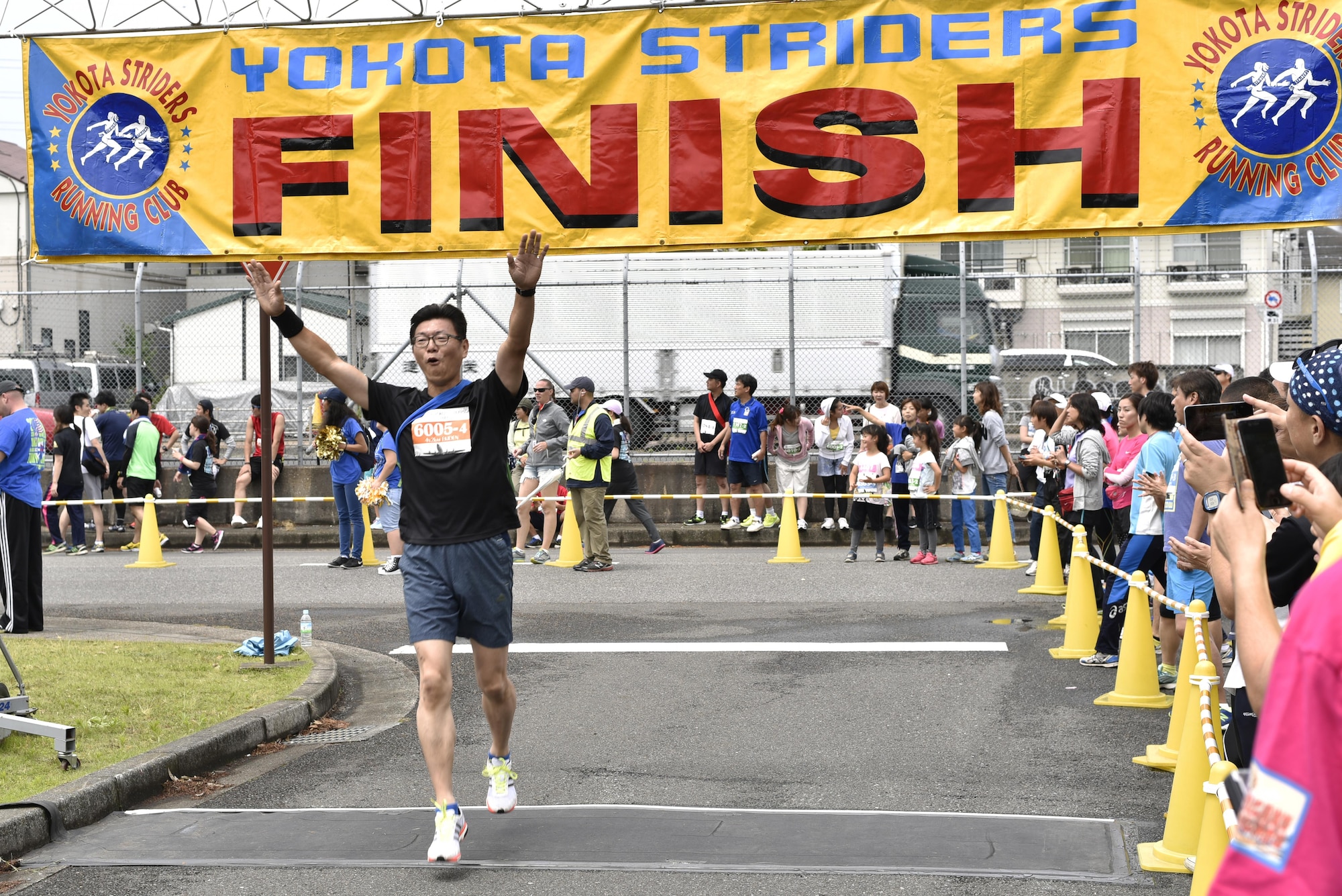 A runner celebrates as he crosses the finish line during the 2016 Ekiden Run at Yokota Air Base, Japan, June 5, 2016. The Ekiden Run consisted of a 2k, 8k and 20k race. (U.S. Air Force photo by Staff Sgt. Michael Washburn/Released)