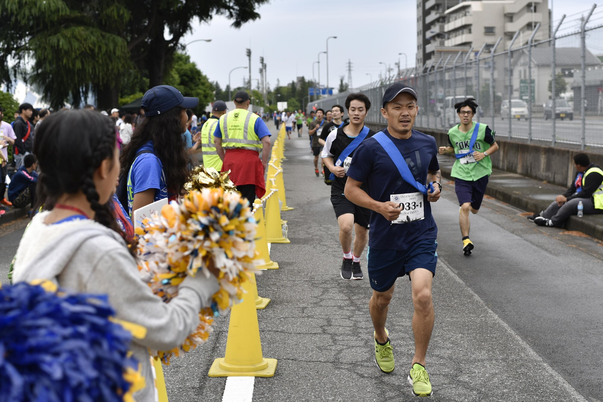 A participant runs past cheering onlookers during the 2016 Ekiden Run at Yokota Air Base, Japan, June 5, 2016. The Ekiden Run consisted of a 2k, 8k and 20k race. (U.S. Air Force photo by Staff Sgt. Michael Washburn/Released)