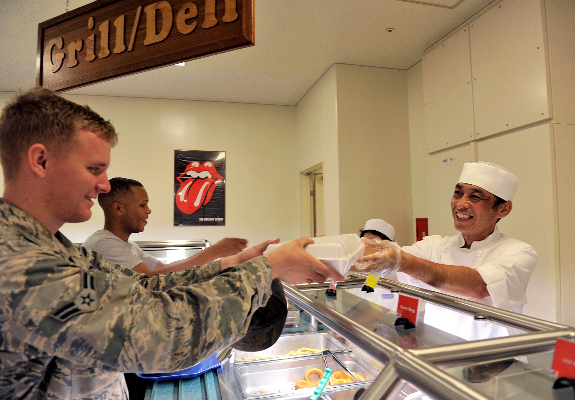 Takashi Seragaki, 18th Force Support Squadron cook, serves a meal to an Airman at the Marshall Dining Facility, June 3, 2016, at Kadena Air Base, Japan. Seragaki said he feels satisfied when he sees customers enjoying the meals he worked hard to make. (U.S. Air Force photo by Naoto Anazawa)

