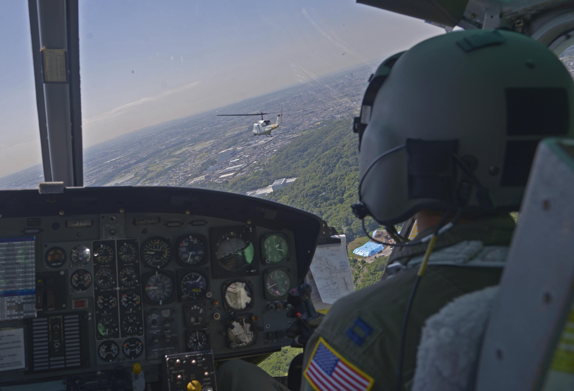 Capt. Johnathan Bonilla, 459th Airlift Squadron UH-1N instructor pilot, follows a UH-1N Iroquois during formation flight training over Japan, June 3, 2016. The formation flight provided the aircrew with an opportunity to practice flight procedures and prepare for real-world missions. (U.S. Air Force photo by Senior Airman David Owsianka/Released)