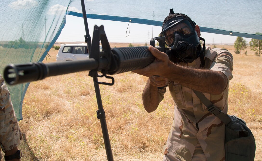 A Peshmerga soldier practices aiming down his sights while wearing a chemical protective mask during a chemical, biological, radiological, and nuclear class at a base near Erbil, Iraq, May 25, 2016. As part of a 10-week basic infantry course, CBRN training is provided to Peshmerga soldiers to aid in the fight against ISIL.  (Army Photo by Spc. Jaquan P. Turnbow)