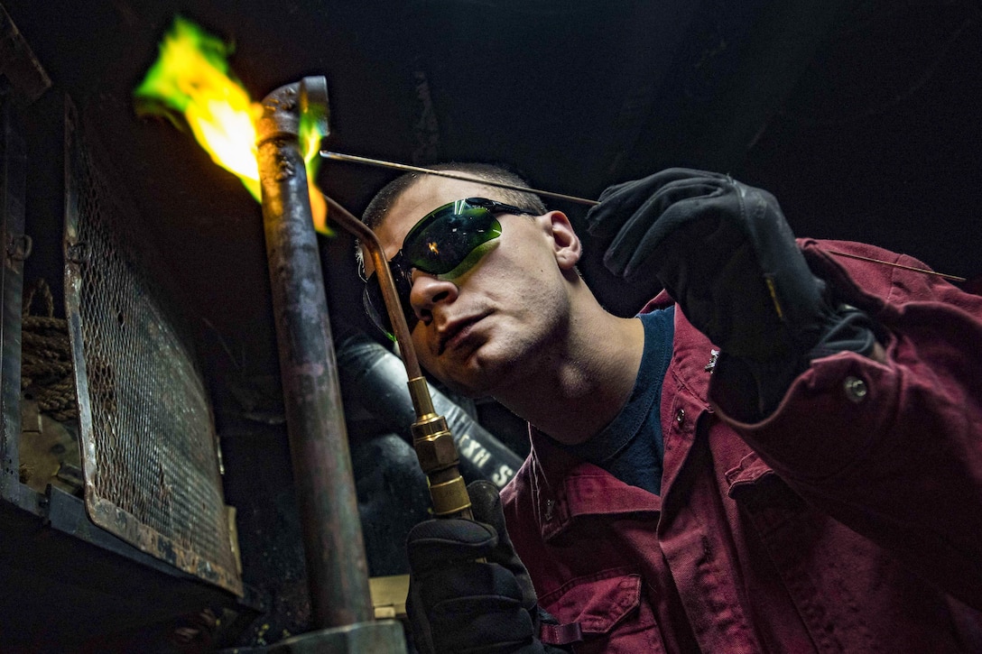 Navy Petty Officer 2nd Class Jonathan Allen brazes together metal fittings in the pipe shop aboard the USS Dwight D. Eisenhower in the Atlantic Ocean, June 6, 2016. The ship is supporting maritime security operations in the areas of responsibility for the U.S. 5th and 6th fleets. Navy photo by Petty Officer 3rd Class Anderson W. Branch