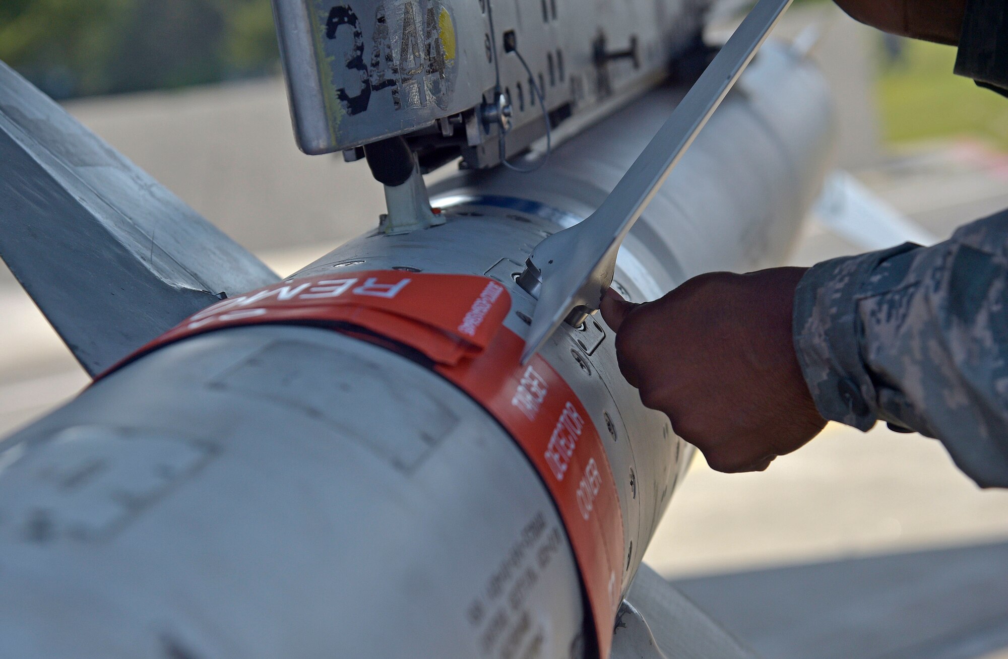 U.S. Air Force Senior Airman Mitchell Gibson, an armament systems specialist with the 35th Aircraft Maintenance Squadron, tightens a fin on an AGM-88 high-speed anti-radiation missile at Misawa Air Base, Japan, June 6, 2016. Airmen from the 35th Operations and Maintenance Groups underwent a three-day surge, which increased the operations tempo, similar to that experienced during real world wartime scenarios. Armament Airmen simulated arming F-16 Fighting Falcons throughout all hours of the day. (U.S. Air Force photo by Senior Airman Deana Heitzman) 