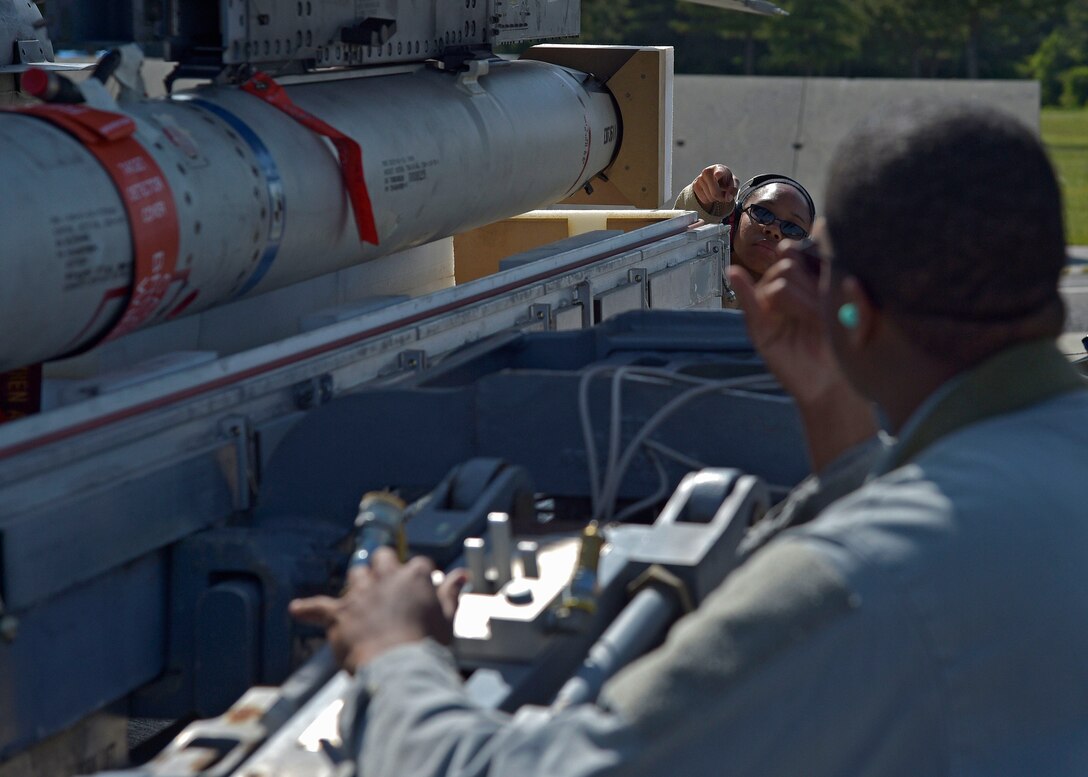 U.S. Air Force Airman 1st Class Lanell Lewis signals Staff Sgt. Miles Smith, both armament systems specialists with the 35th Aircraft Maintenance Squadron, to maneuver an AGM-88 high-speed anti-radiation missile out of a housing casket at Misawa Air Base, Japan, June 6, 2016. Smith operate a MHU-83 lift truck to load weapons onto an F-16 Fighting Falcon during a three-day surge to practice and improve combat readiness, readying for wartime loading scenarios. (U.S. Air Force photo by Senior Airman Deana Heitzman) 