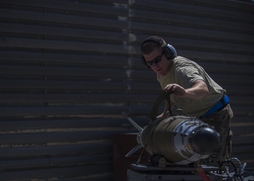Technical Sgt. Joseph McCullough, 455th Expeditionary Aircraft Maintenance Squadron weapons maintainer, straps down a GBU (Guided Bomb Unit)-54 to a munitions loader at Bagram Airfield, Afghanistan, June 07, 2016. The 455th EAMXS weapons flight load F-16s with both offensive and defensive explosive devices to support various air tasking orders. (U.S. Air Force photo by Senior Airman Justyn M. Freeman)