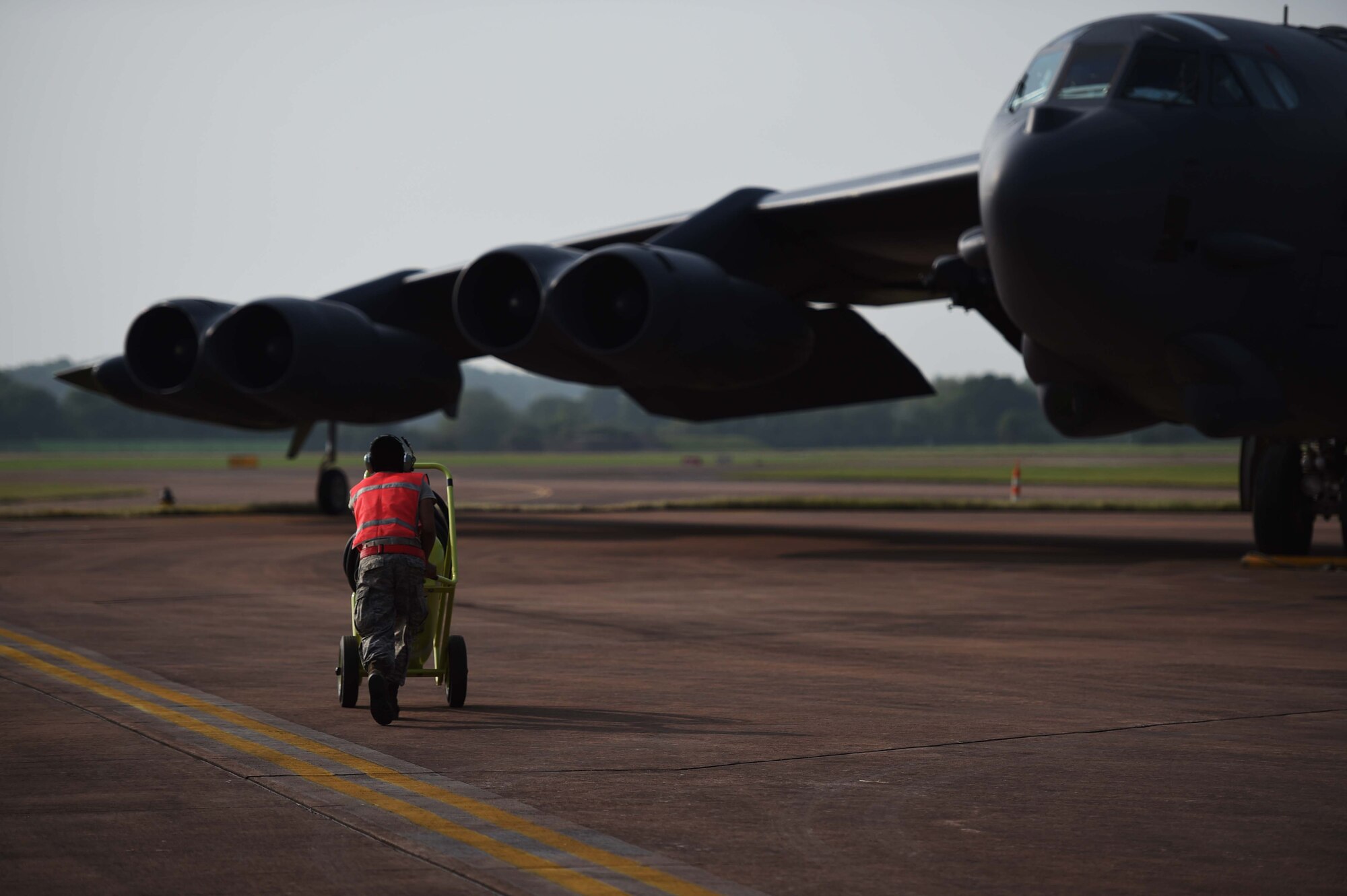 A maintenance Airman from Minot Air Force Base, N.D., runs to a B-52H Stratofortress as it parks on RAF Fairford, United Kingdom, June 7, 2016, after flying a training sortie in support of exercise BALTOPS 16. The mission trained the aircrew on air interdiction and interoperability with sister services and partner nations. (U.S. Air Force photo by Airman 1st Class Zachary Bumpus)